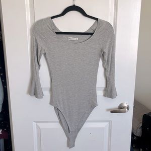 Bodysuit with snap enclosure and fluttery sleeves that end at the elbow